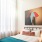 bed next to large window with sunlight pouring into bedroom